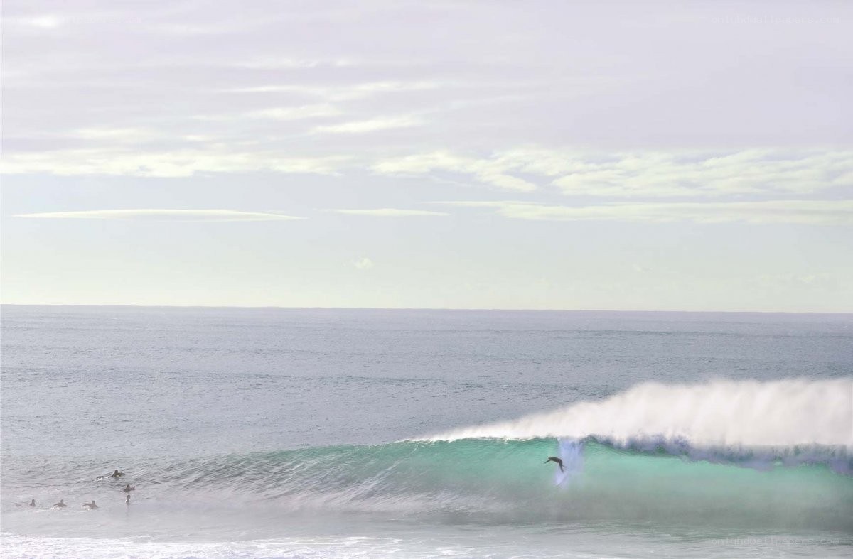 Surfer riding wave at ocean