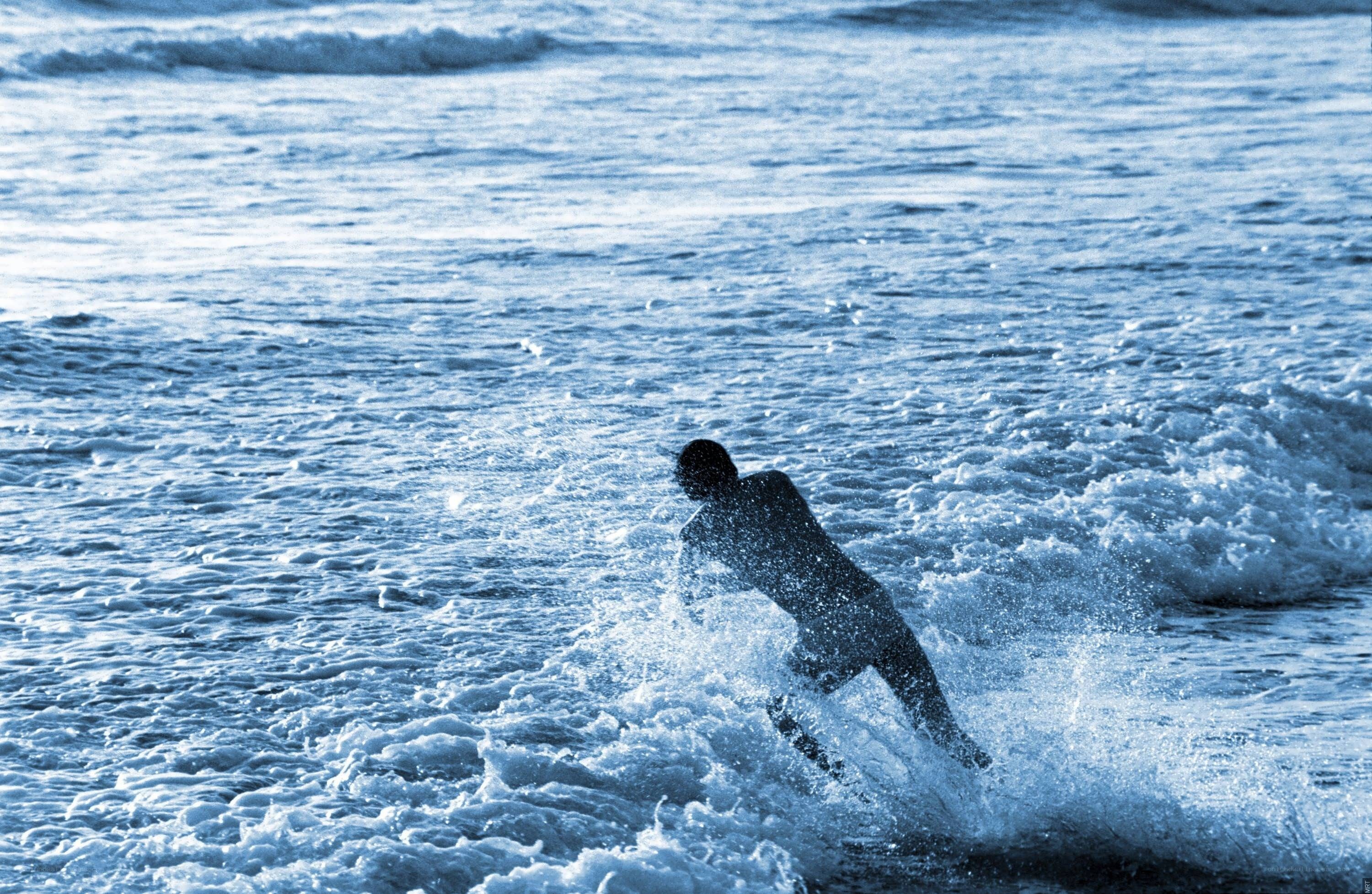 Surfer riding wave at sea
