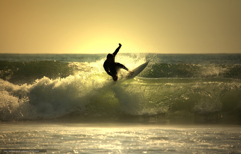 Surfer riding wave at sunset