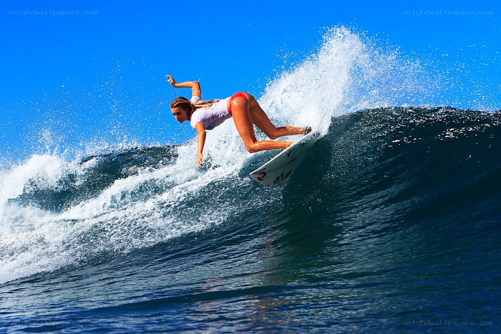 Surfer riding wave in bikini