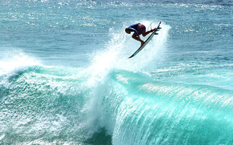 Surfer riding wave in mid-air