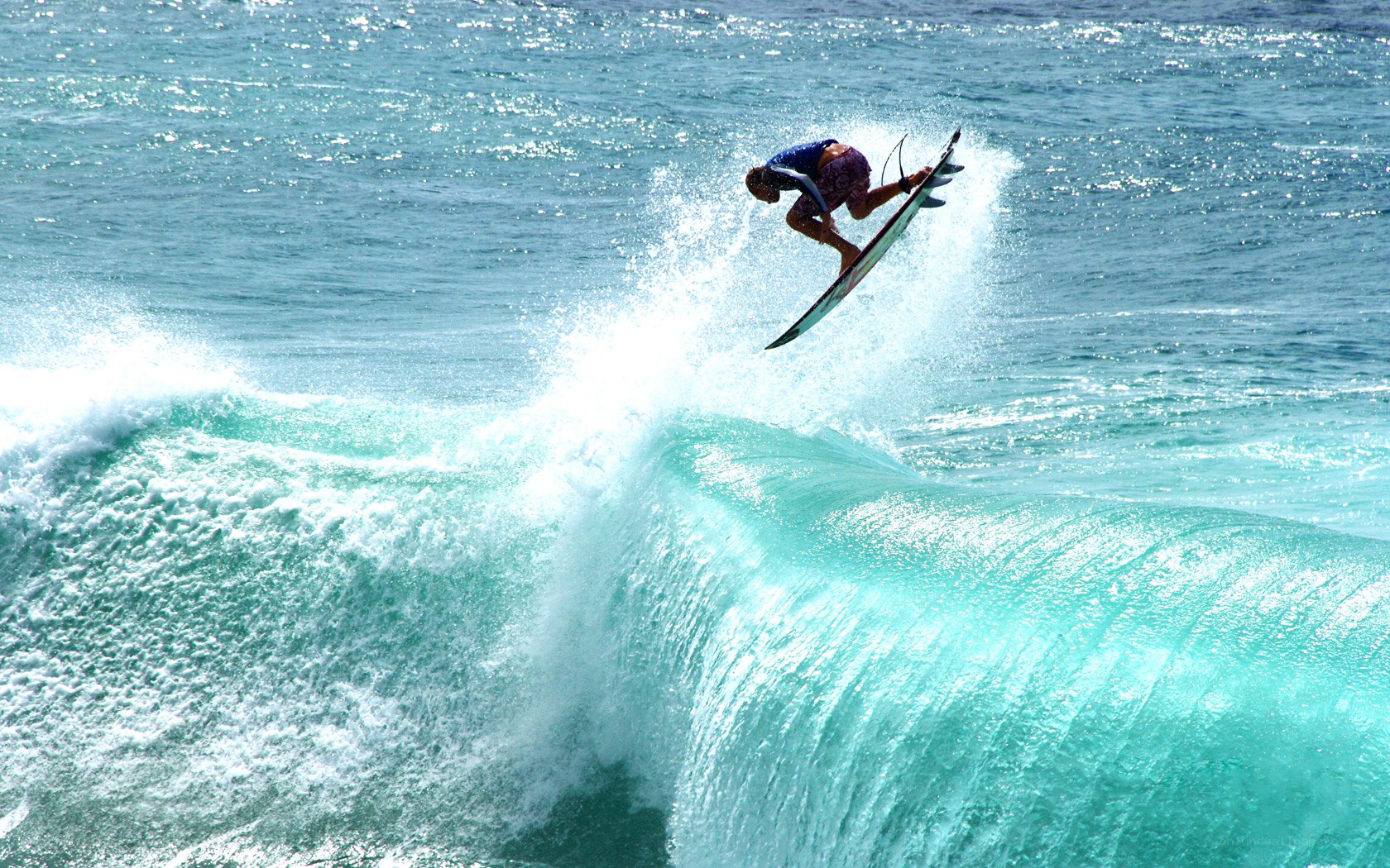 Surfer riding wave in mid-air