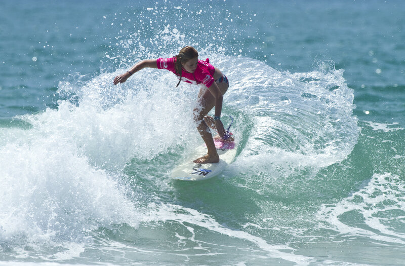 Surfer riding wave in pink shirt