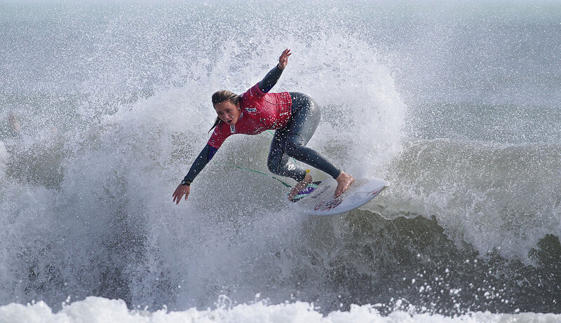 Surfer riding wave in red jersey