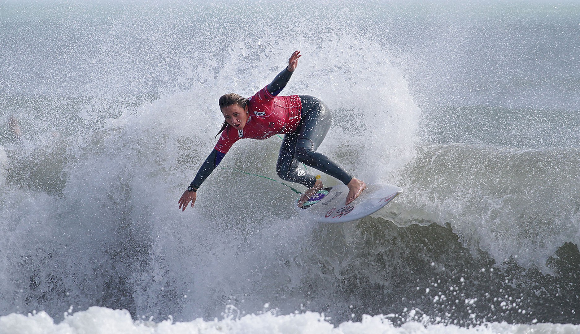 Surfer riding wave in red jersey