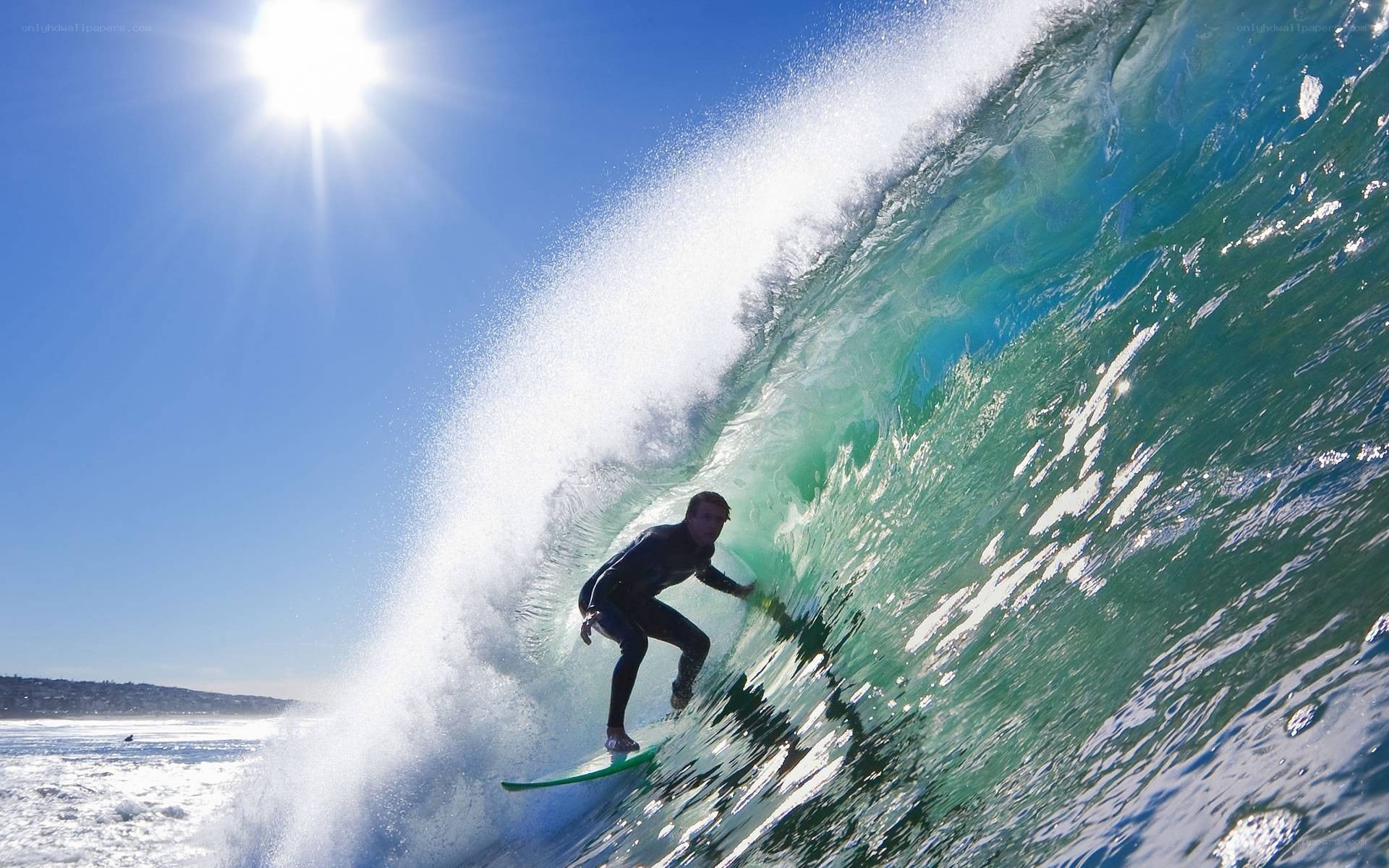 Surfer riding wave in sunlight