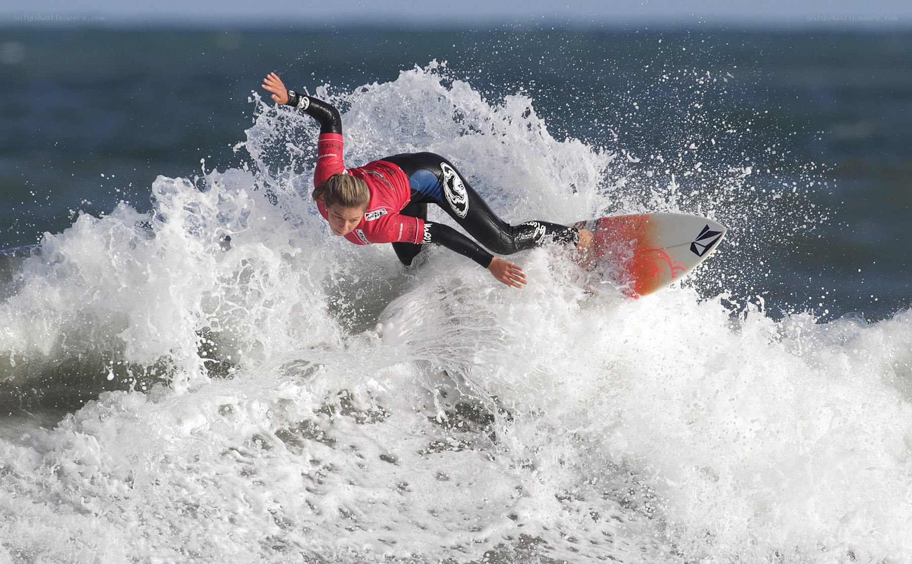 Surfer riding wave in wetsuit