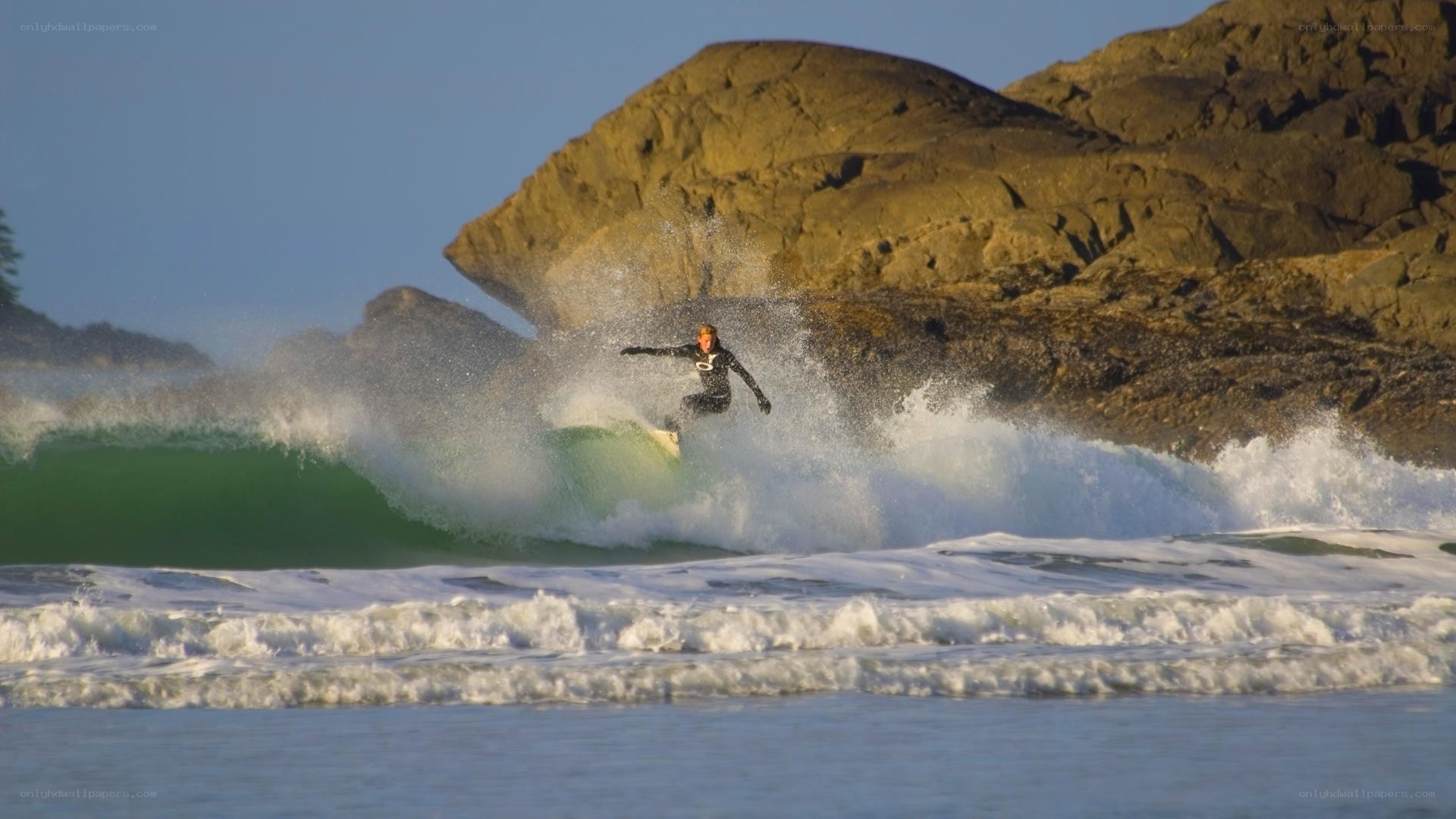 surfer riding wave near rocks