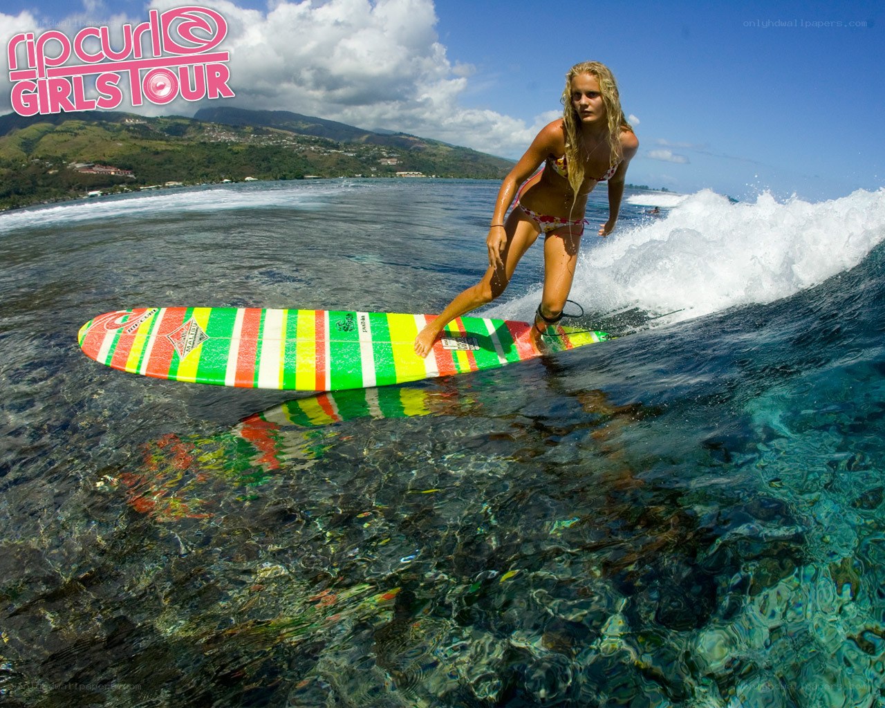 Surfer riding wave on colorful board