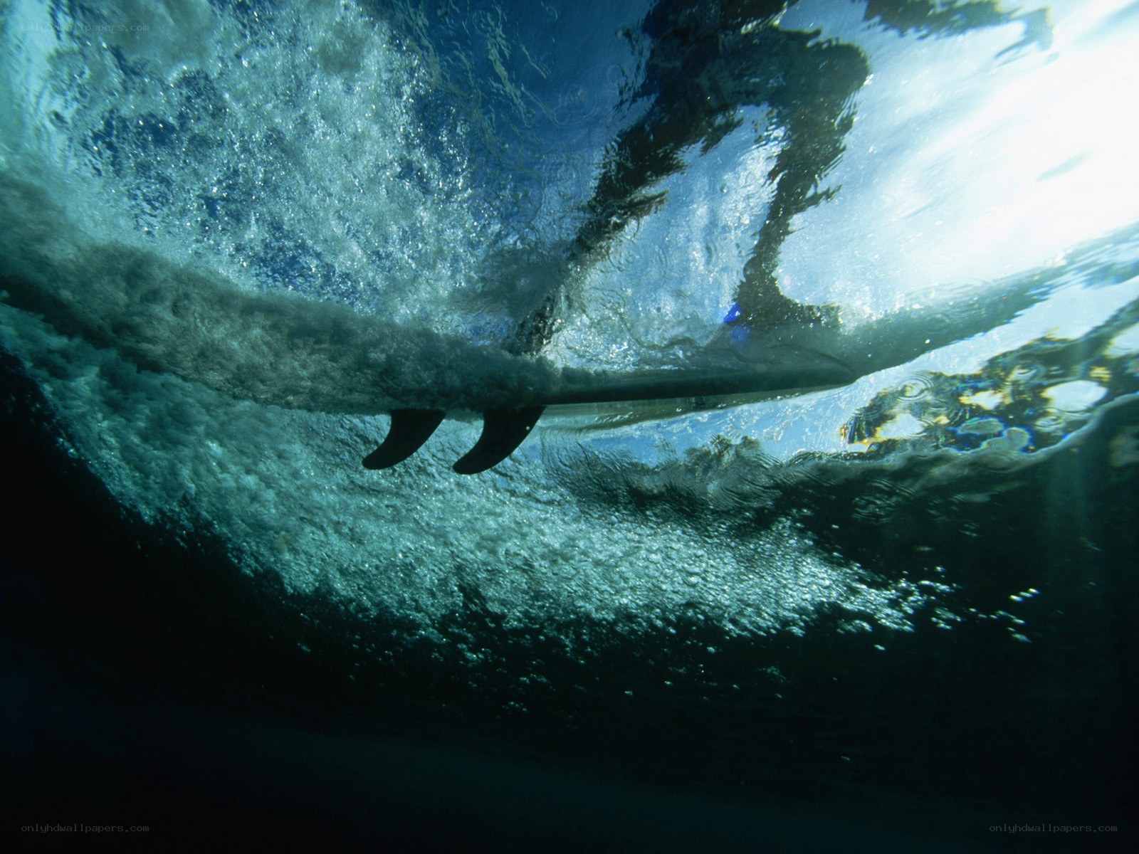 Surfer riding wave underwater