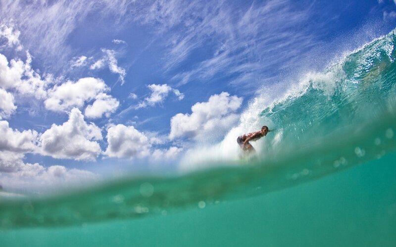 Surfer riding wave underwater