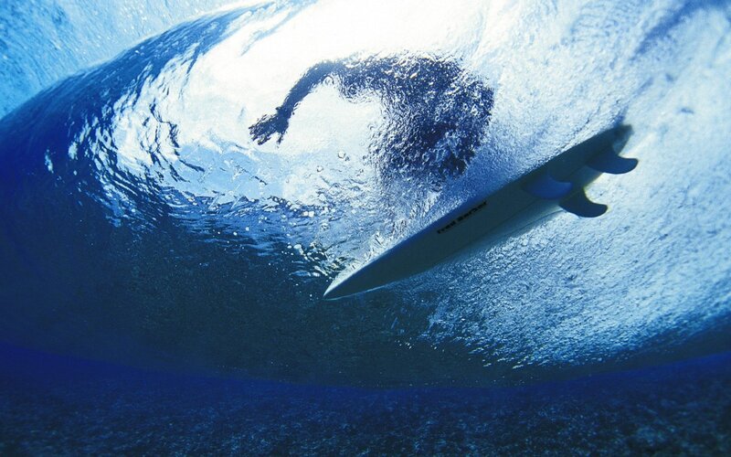 Surfer under a wave