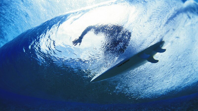 surfer under a wave