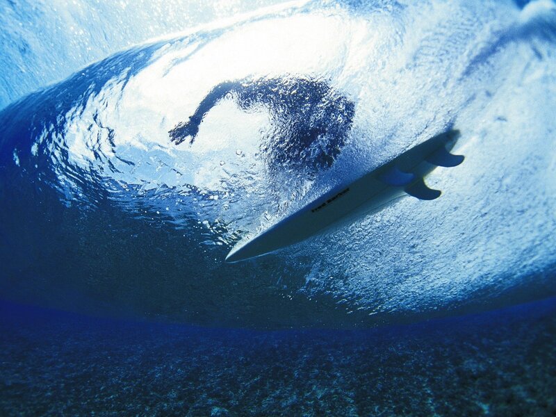 Surfer under a wave