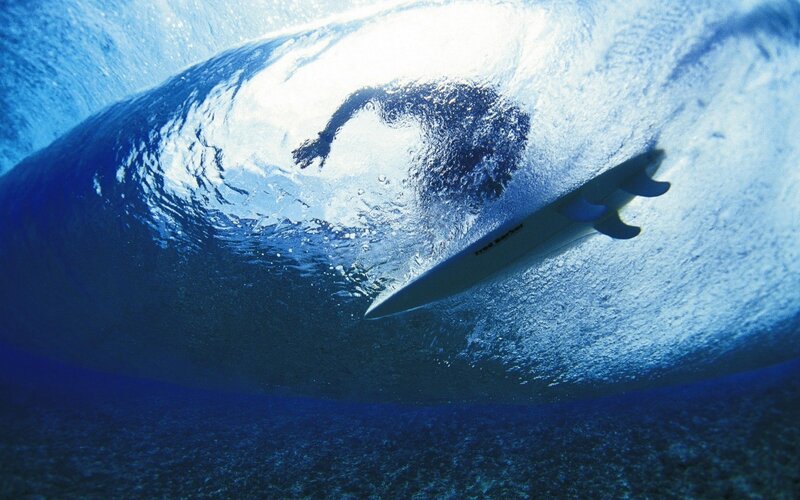 Surfer under a wave