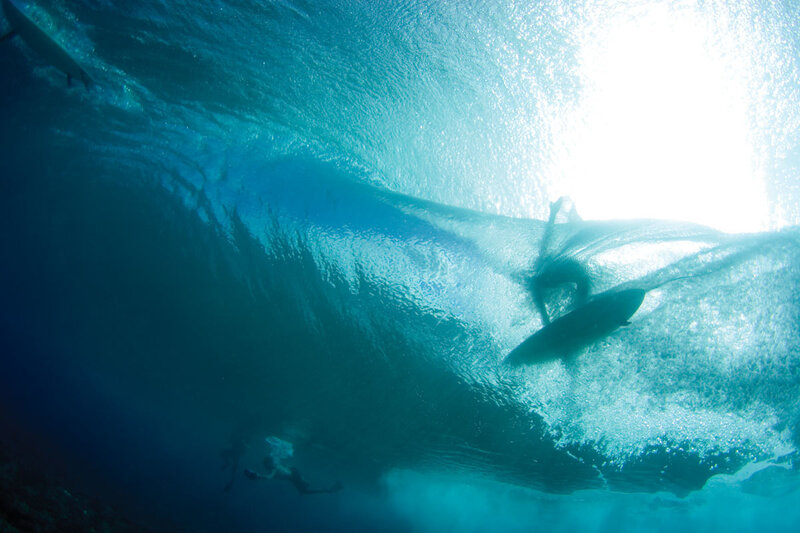 Surfer under a wave