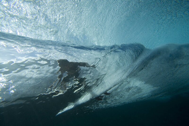 Surfer under a wave