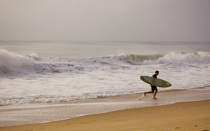 Surfer walking on beach