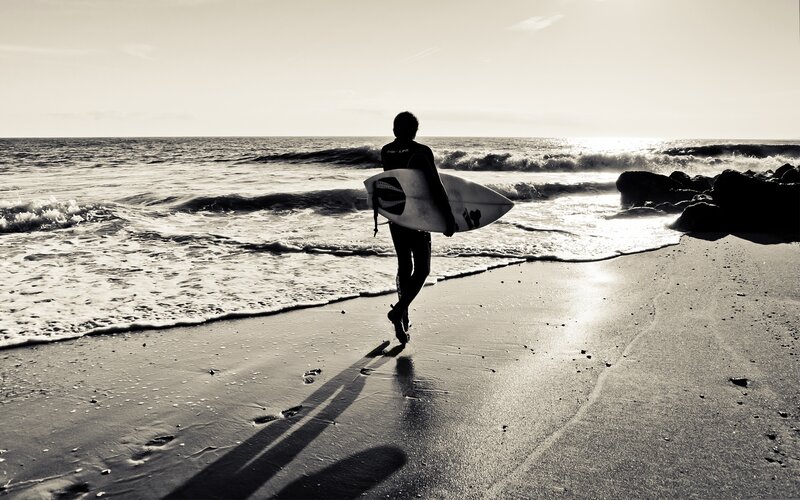 Surfer walking on beach