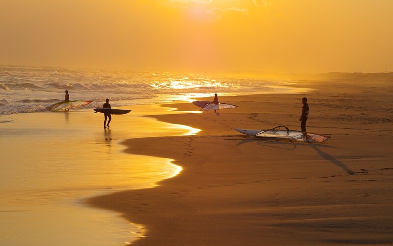 Surfers at sunset on the beach