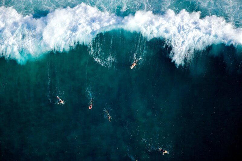 Surfers riding a large wave