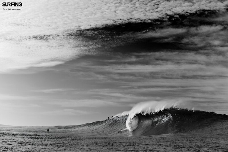 Surfers riding a large wave