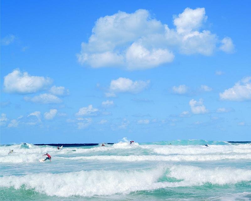 Surfers riding waves on a sunny day
