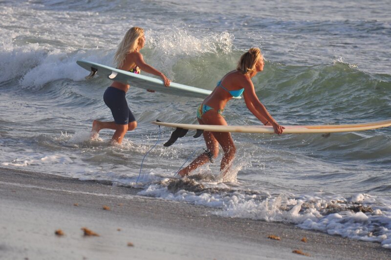 Surfers running into the ocean