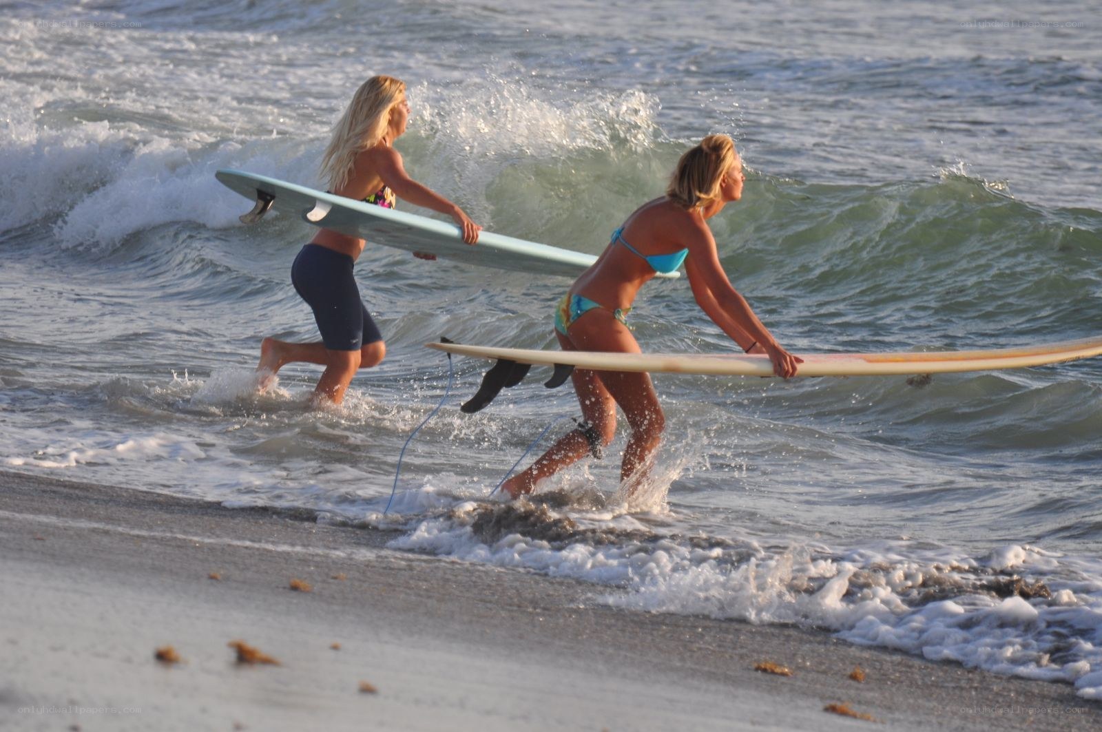 Surfers running into the ocean