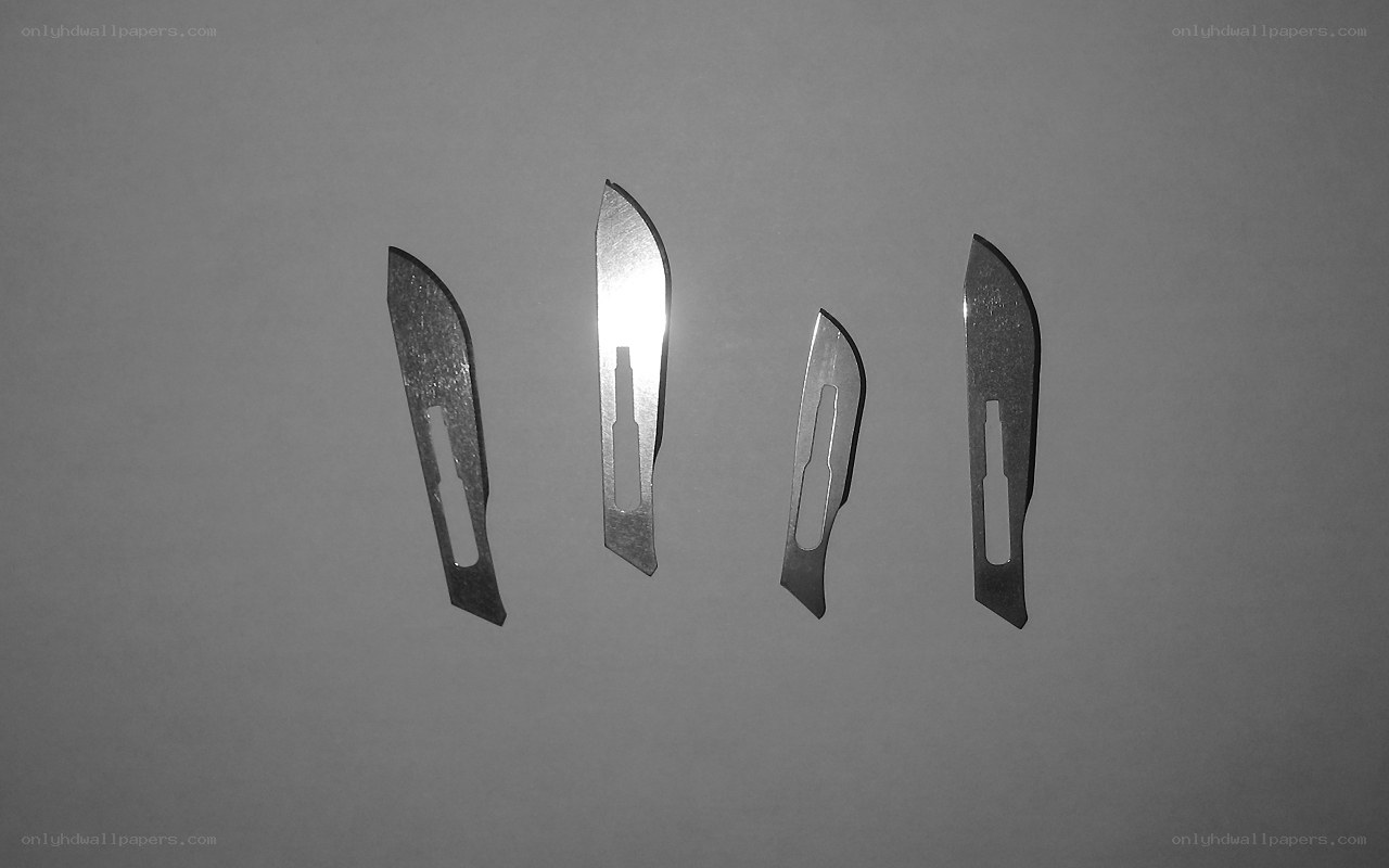 surgical blades on gray surface