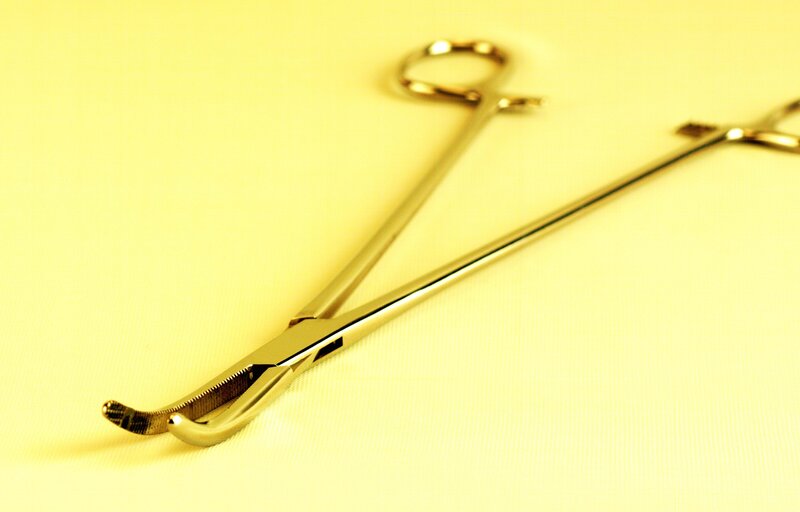 surgical forceps on yellow surface