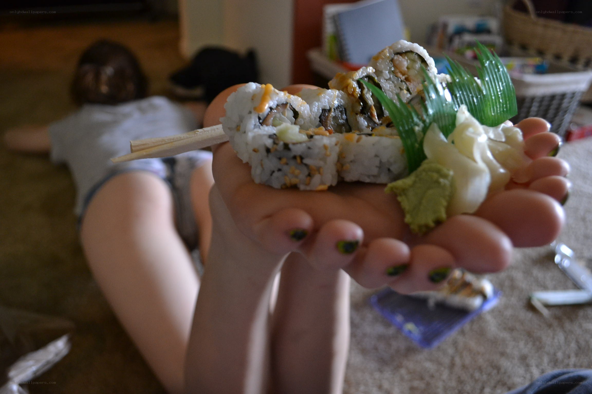 Sushi in hand with person in background