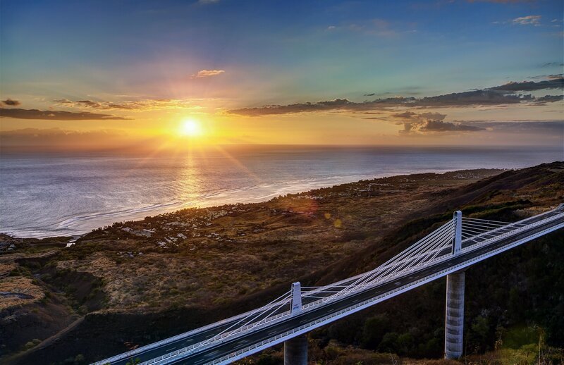Suspension Bridge at Sunset — Blue, Serene, Photograph, Ocean, Sun, Hills