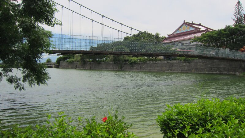 Suspension Bridge over River — Green, Serene, Afternoon, Photograph, Temple