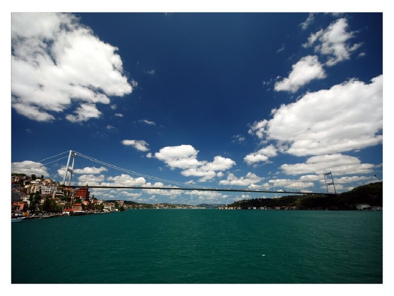 Suspension Bridge over Water — Blue, Serene, Afternoon, Photograph, Clouds