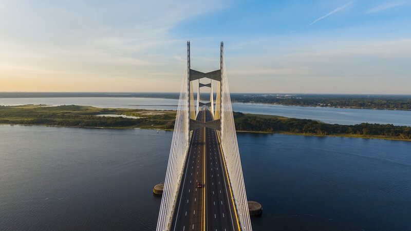 Suspension Bridge over Water — Blue, Serene, Sunset, Photograph, Road