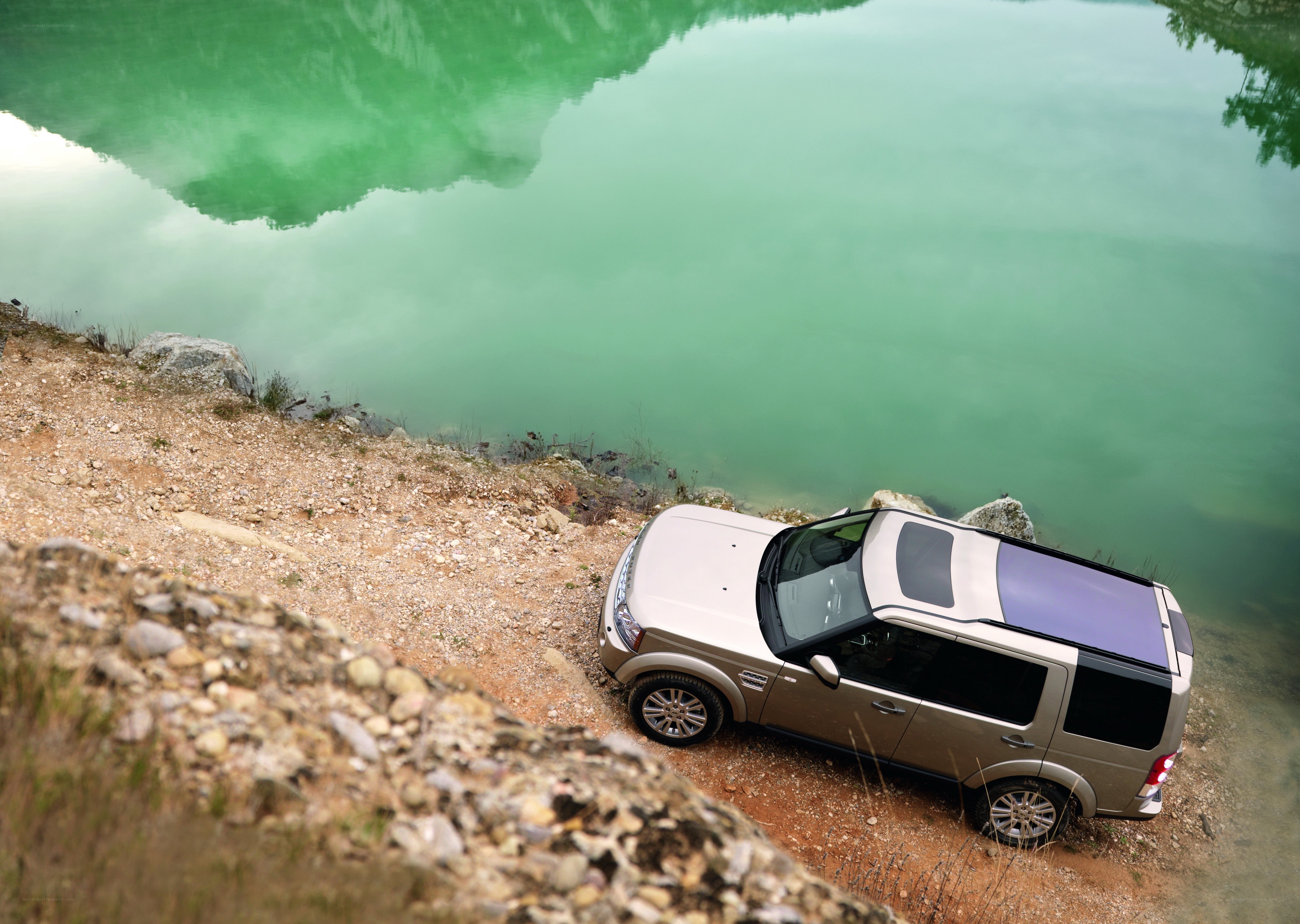 SUV by a green lake