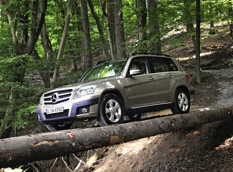 SUV crossing log in forest