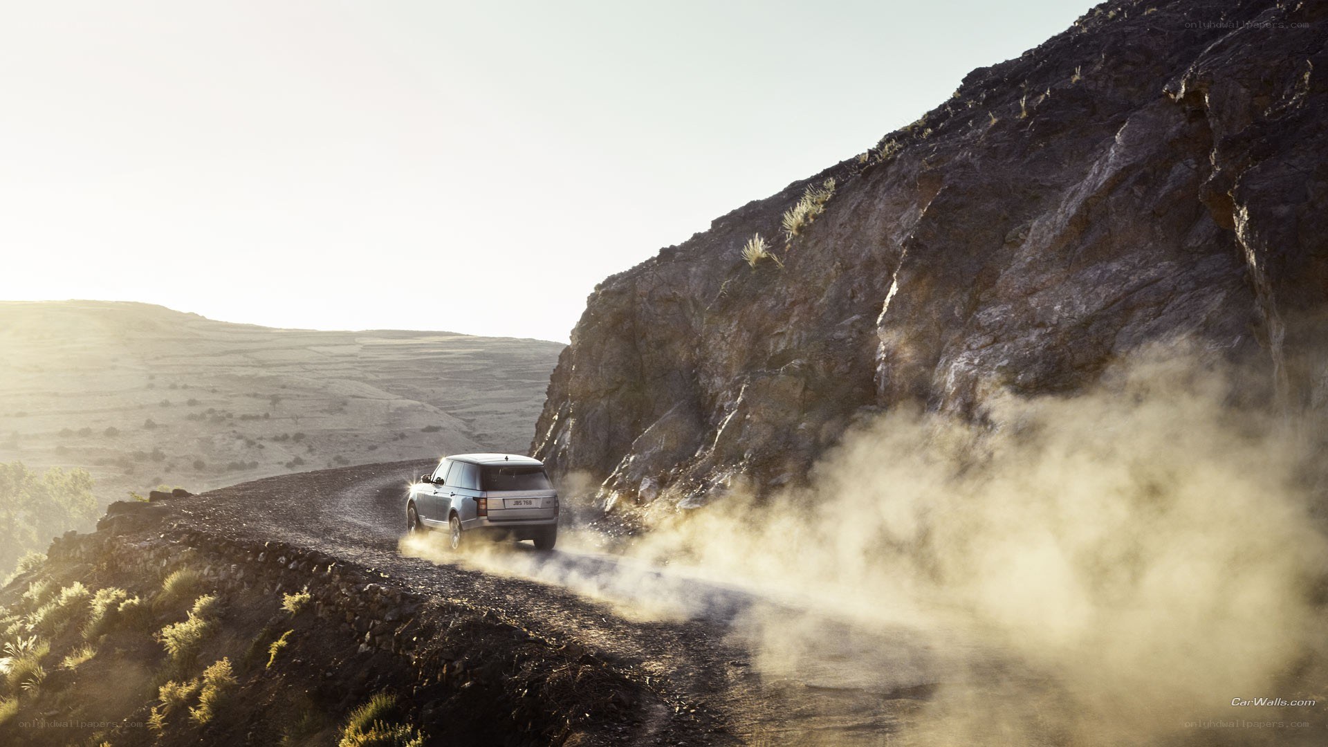 SUV driving on dusty mountain road
