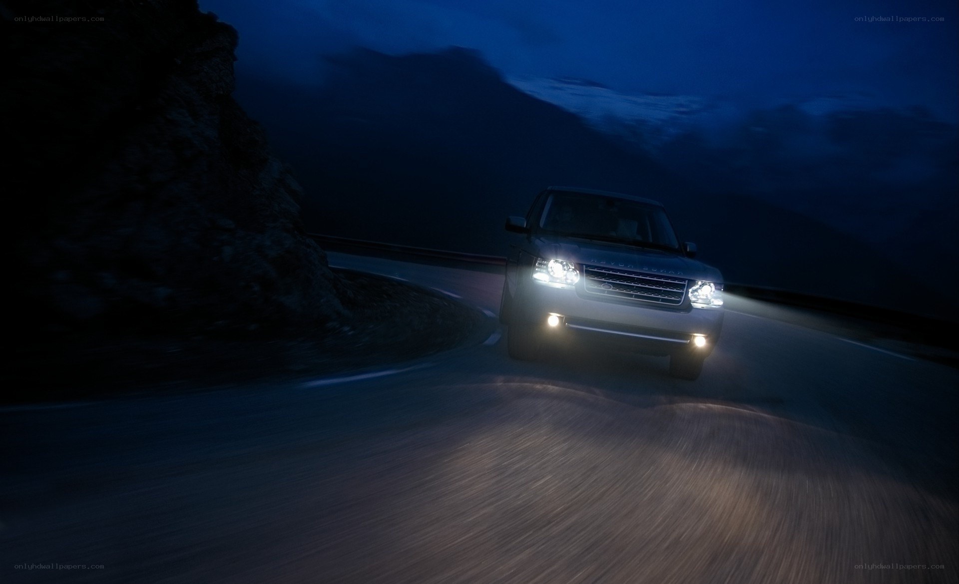 SUV driving on mountain road at night