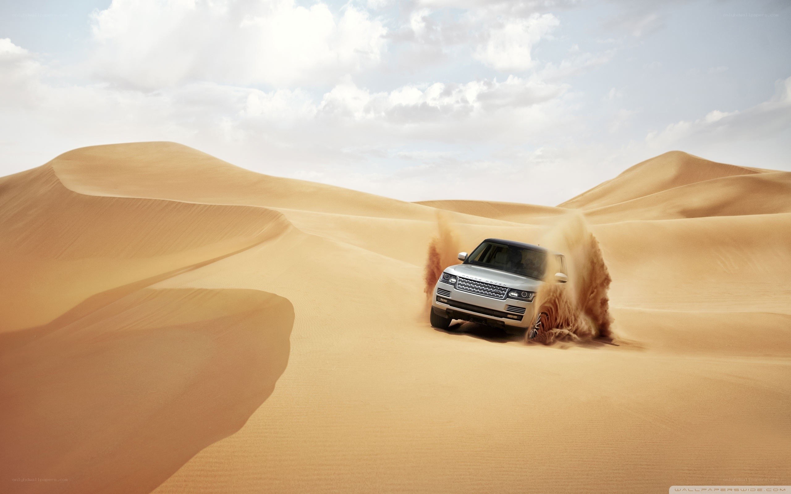 SUV driving through desert dunes
