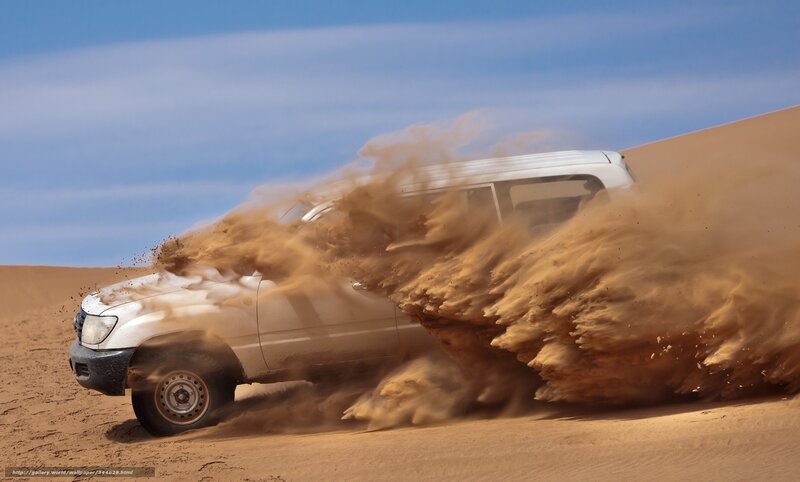 SUV kicking up sand in desert