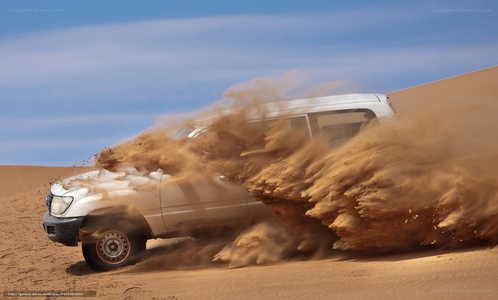 SUV kicking up sand in desert