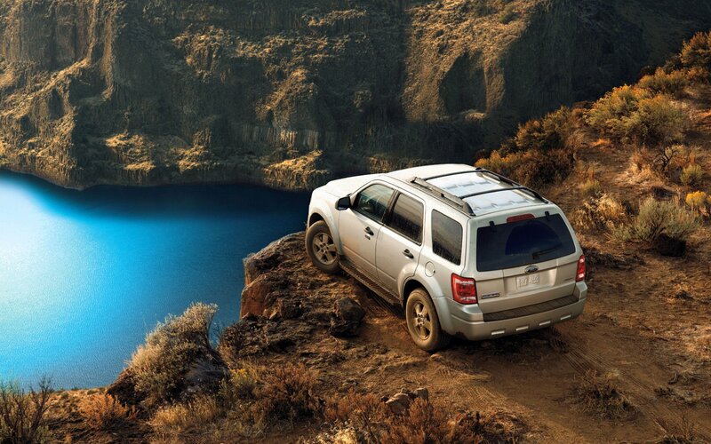 SUV on a cliff overlooking water