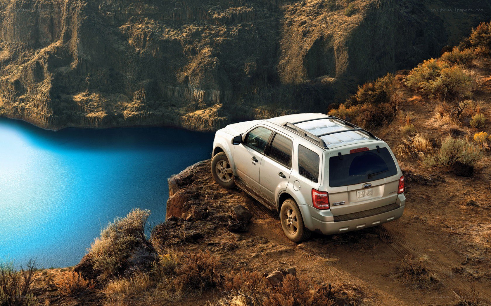 SUV on a cliff overlooking water