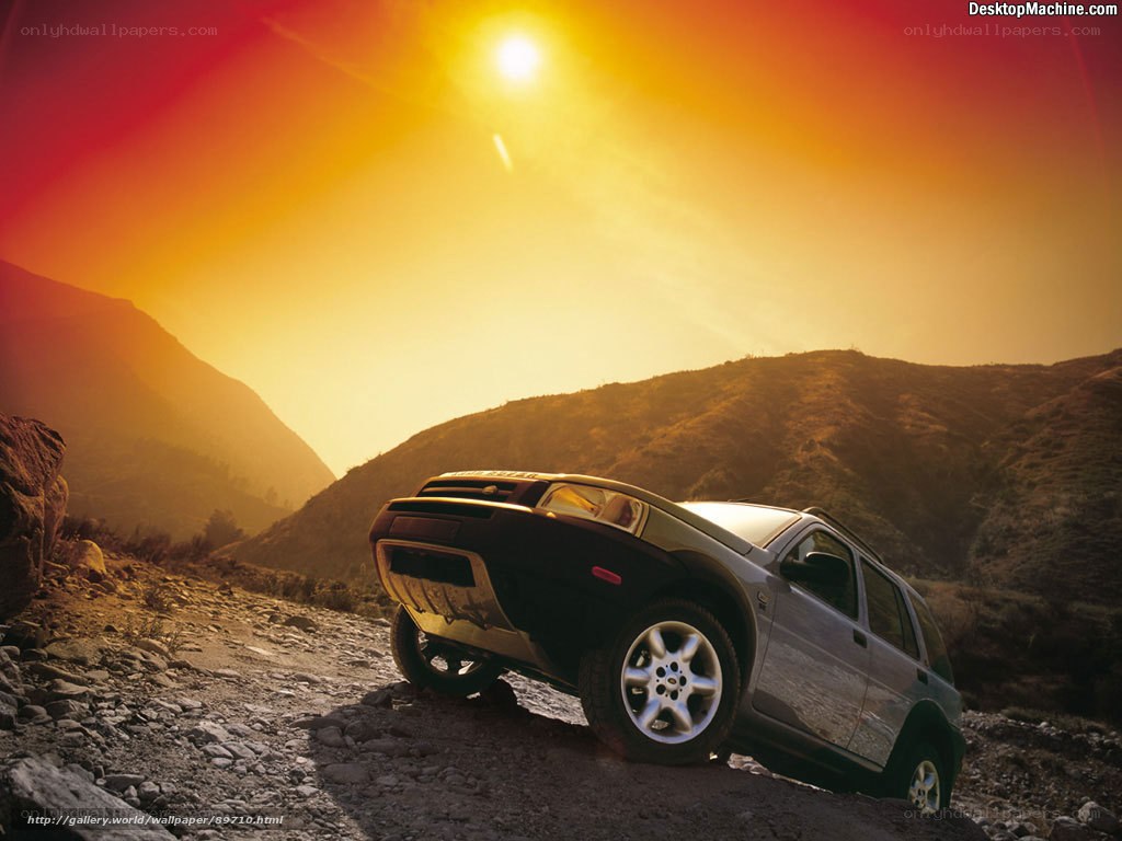 SUV on a rocky hill at sunset