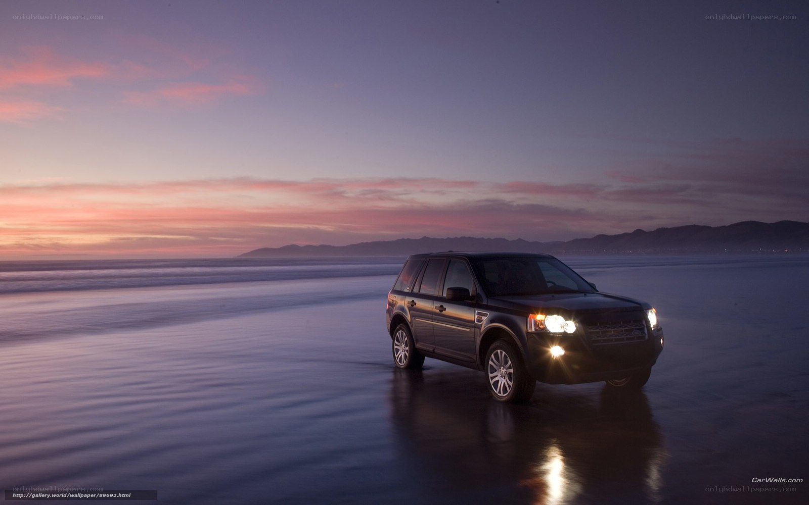 SUV on beach at dusk