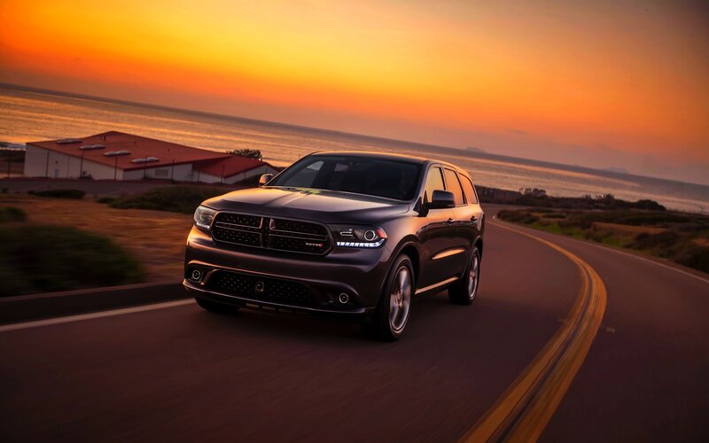 SUV on coastal road at sunset