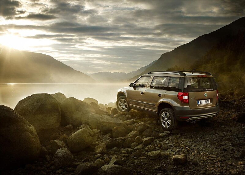 SUV on rocky shore at sunset