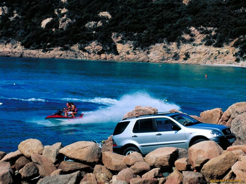 SUV on rocky shore with jet ski
